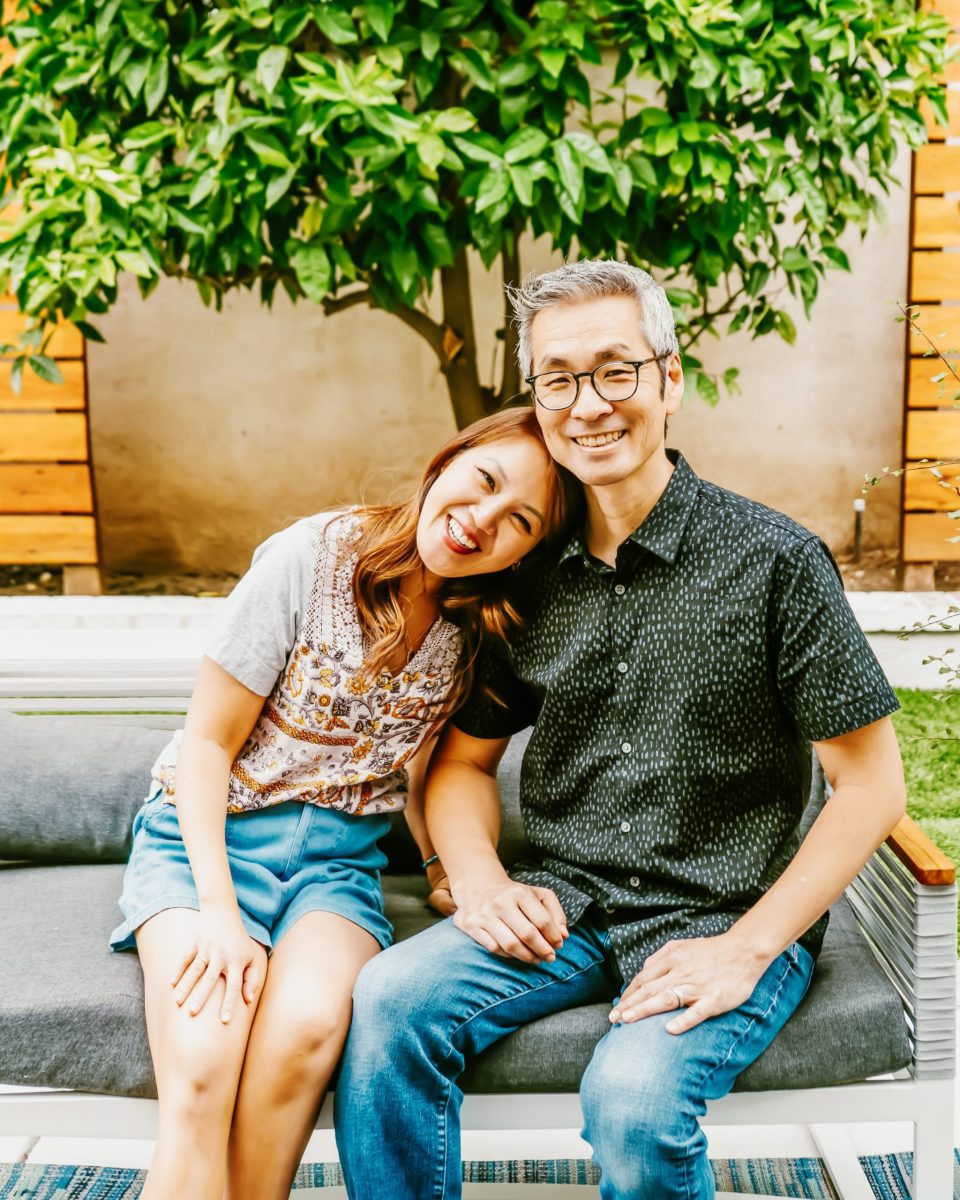 Anita leaning on Travis as they sit together in the backyard