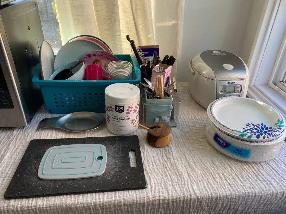 Our makeshift kitchen countertop includes dishes, cutting boards, and sanitizing wipes