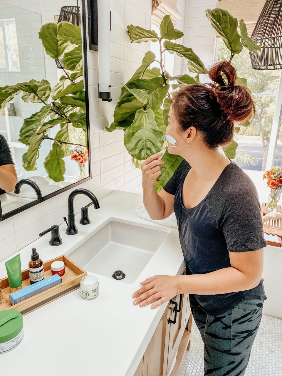 Anita standing at the mirror with a jade roller