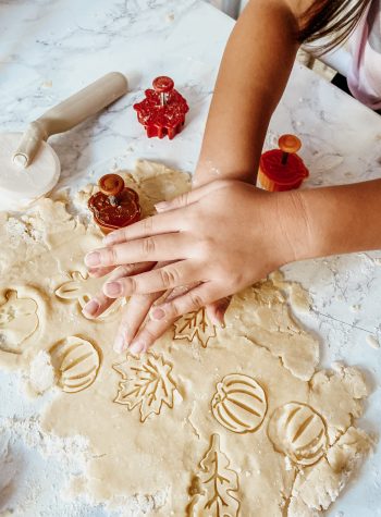 Natalie's teeny hands cutting fall shapes (leaves, pumpkins) into pie dough