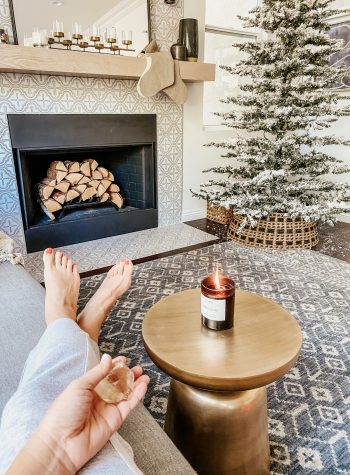 Anita holds a crystal in hand sitting beside the christmas tree