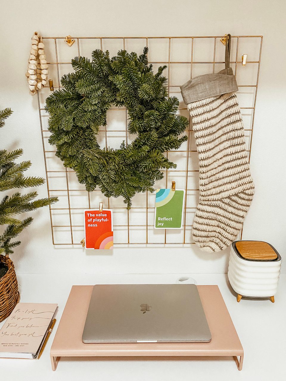 A laptop sits beneath a wreath and a stocking on Anita's desk