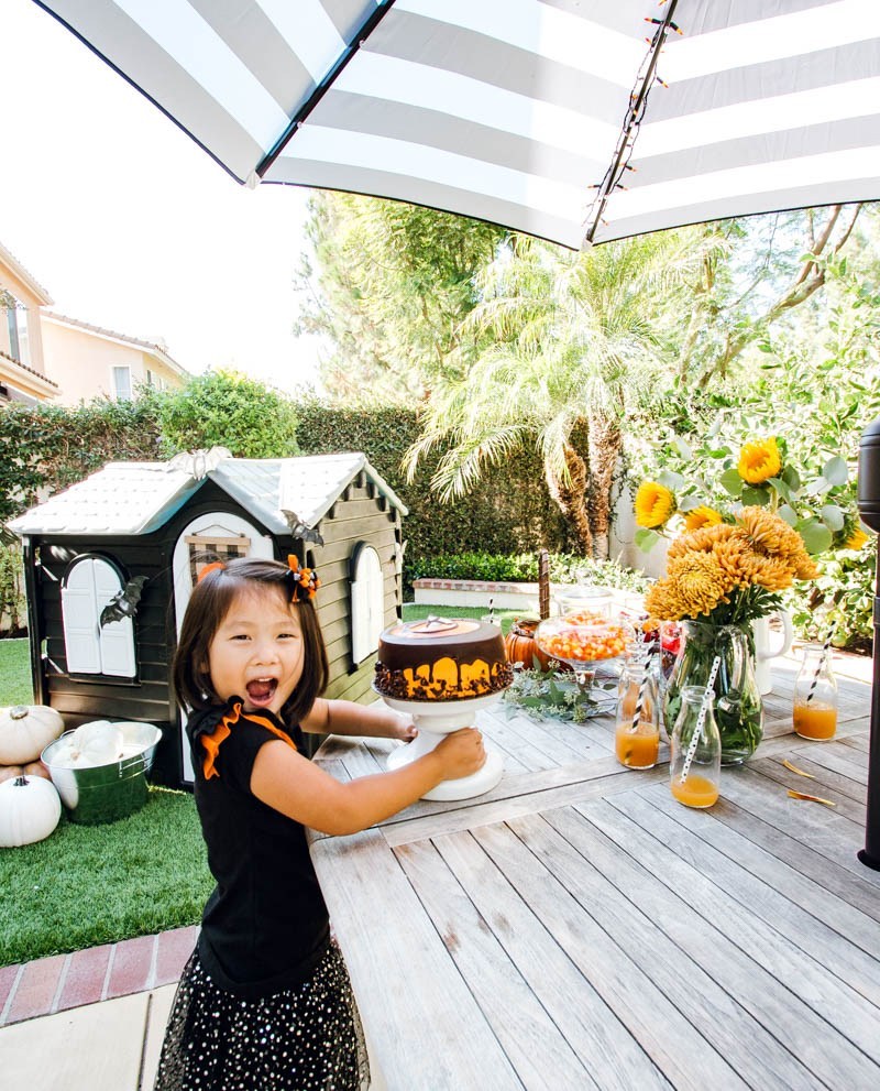 Natalie is pleased as punch in the backyard with her playhouse