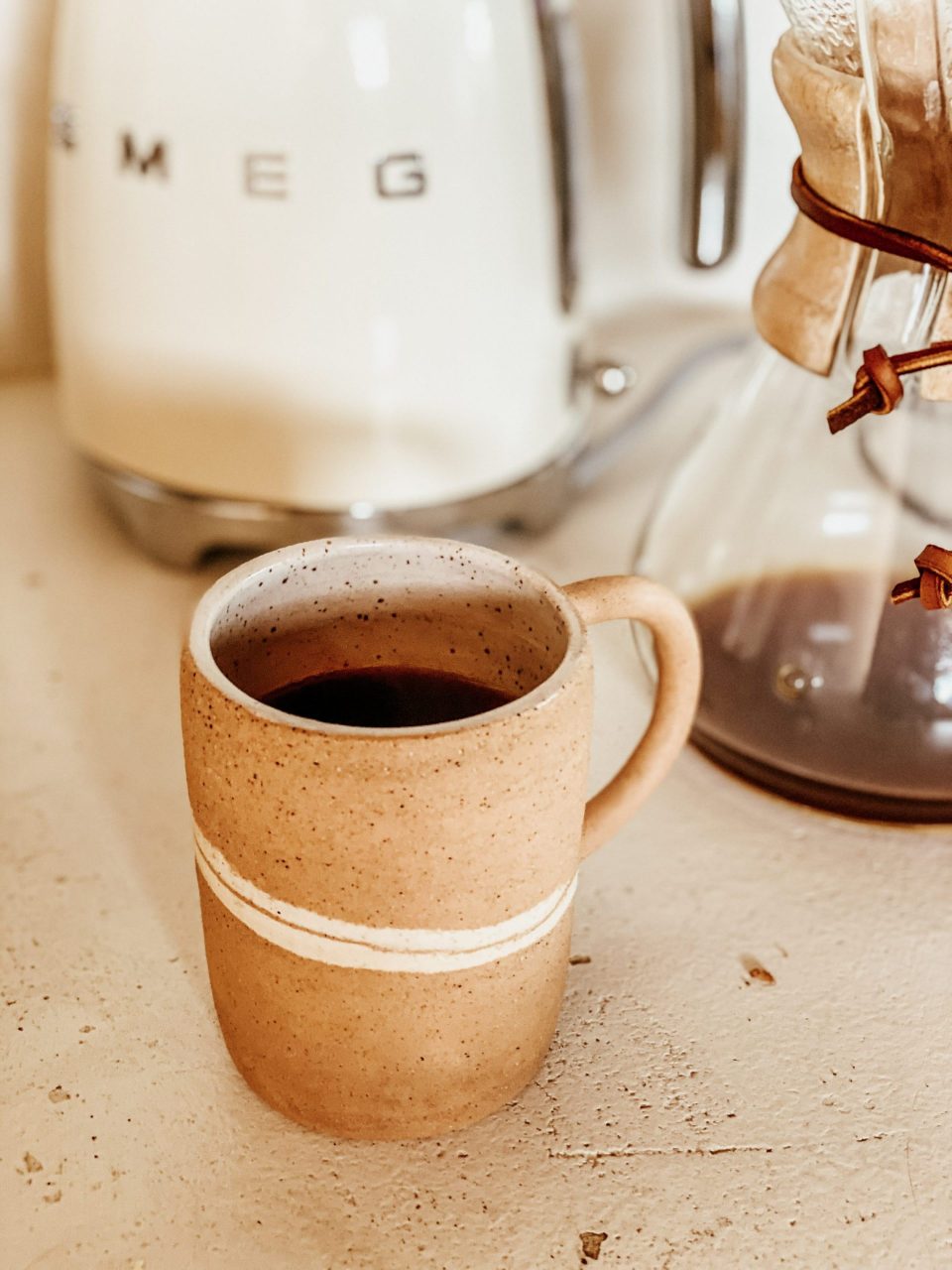 A speckled, ceramic coffee cup, full and ready to drink for a busy morning