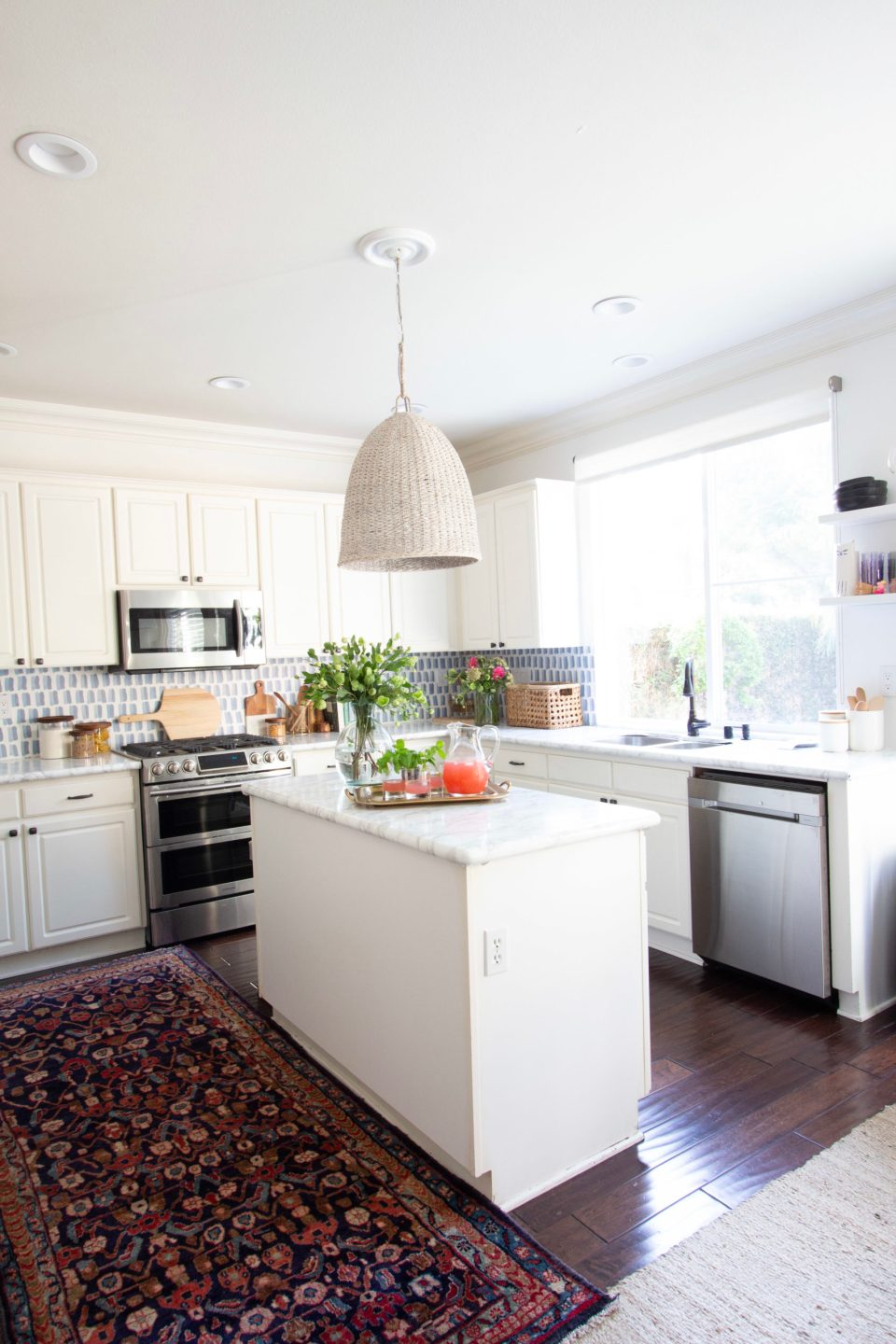 The old island blocks light from the window above the kitchen sink, casting a shadow on the fridge and cabinets