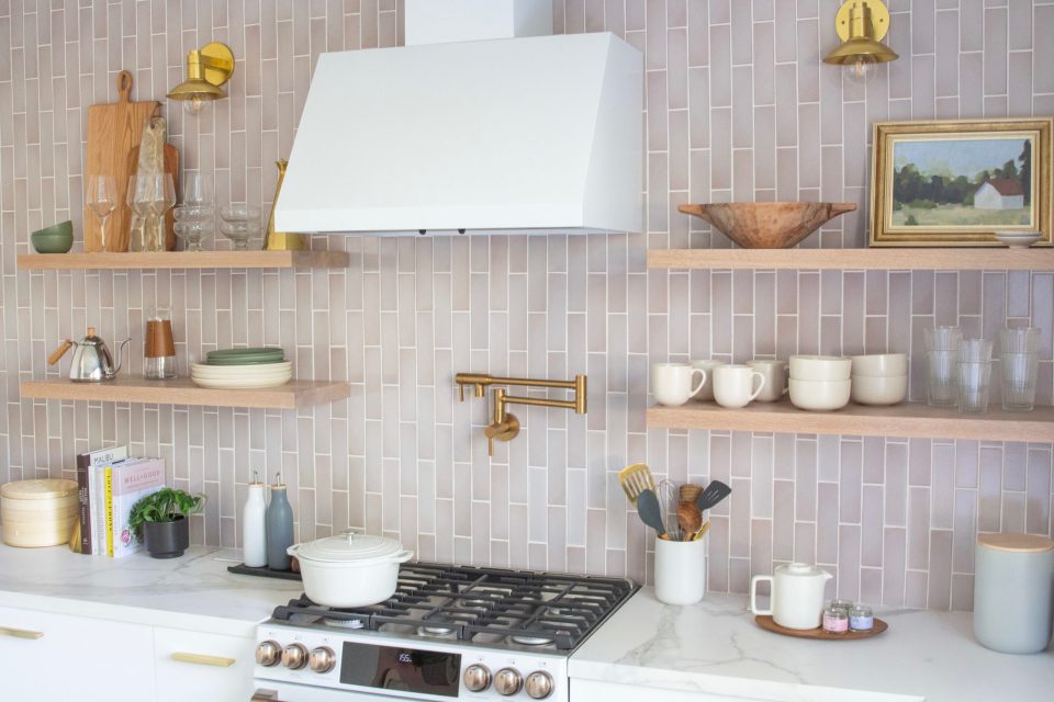 close up of the hanging open shelves with sconces centered above each set of shelves